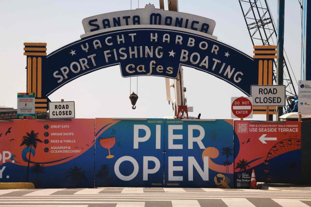 Entrance to the Santa Monica Pier is partially blocked off as workers remove the sign at the end of Route 66 in Santa Monica, California, on October 20, 2026. The landmark Santa Monica Pier sign will begin coming down Tuesday for restoration in Las Vegas as part of a project to replace the aging bridge connecting Ocean Avenue to the pier, city officials announced. The sign is listed on the California Register of Historical Resources and is expected to return to the pier entrance when construction of the new bridge is completed in 2028, according to the city. (Photo by David Swanson / AFP)