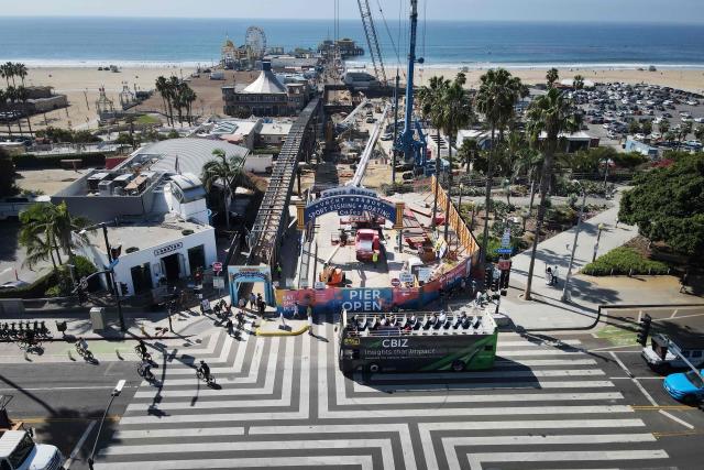 Workers remove the Santa Monica Pier sign at the end of Route 66 in Santa Monica, California, on October 20, 2026. The landmark Santa Monica Pier sign will begin coming down Tuesday for restoration in Las Vegas as part of a project to replace the aging bridge connecting Ocean Avenue to the pier, city officials announced. The sign is listed on the California Register of Historical Resources and is expected to return to the pier entrance when construction of the new bridge is completed in 2028, according to the city. (Photo by David Swanson / AFP)