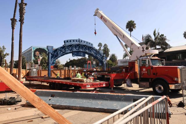 Workers remove the Santa Monica Pier sign at the end of Route 66 in Santa Monica, California, on October 20, 2026. The landmark Santa Monica Pier sign will begin coming down Tuesday for restoration in Las Vegas as part of a project to replace the aging bridge connecting Ocean Avenue to the pier, city officials announced. The sign is listed on the California Register of Historical Resources and is expected to return to the pier entrance when construction of the new bridge is completed in 2028, according to the city. (Photo by David Swanson / AFP)