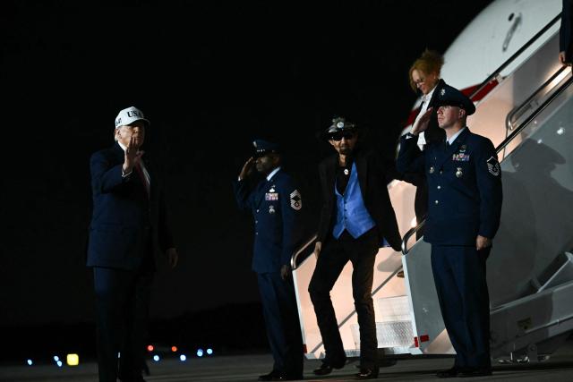 US President Donald Trump gestures as US race car driver Richard Petty disembarks Air Force One at Pitt-Greenville Airport in Greenville, North Carolina, on October 20, 2026. (Photo by Kent NISHIMURA / AFP)