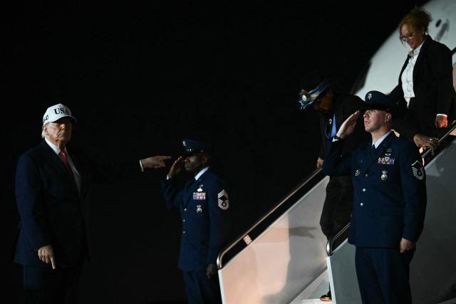 US President Donald Trump points to US race car driver Richard Petty as they disembark Air Force One at Pitt-Greenville Airport in Greenville, North Carolina, on October 20, 2026. (Photo by Kent NISHIMURA / AFP)