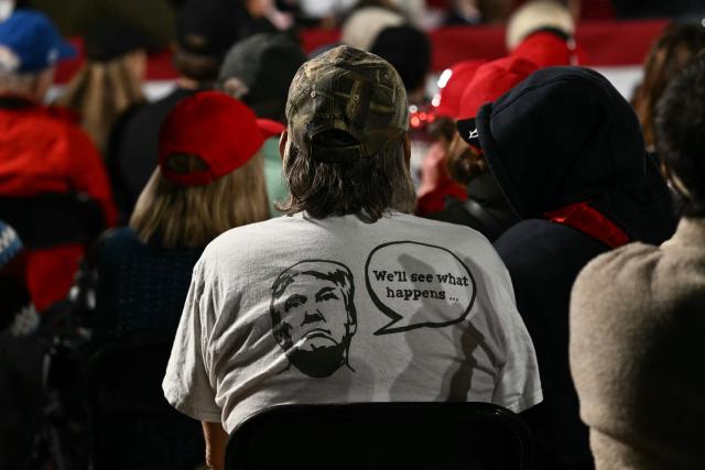 A supporter wearing a Trump shirt is seen as US President Donald Trump speaks at a midterm campaign rally at Pitt-Greenville Airport in Greenville, North Carolina, on October 20, 2026. (Photo by Kent NISHIMURA / AFP)