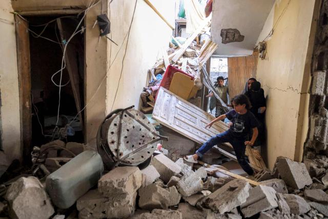 TOPSHOT - A boy walks through the debris and rubble in a heavily-damaged building in the aftermath of a reported missile attack on a residential neighbourhood in Taiz in western Yemen on October 20, 2026. (Photo by Ahmad AL-BASHA / AFP)