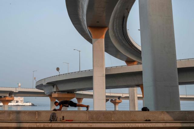 A man exercises at the seafront during the morning hours in Mumbai on October 21, 2026. (Photo by Punit PARANJPE / AFP)