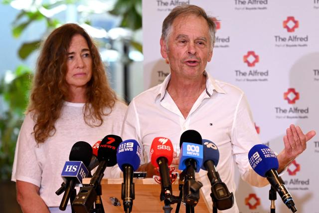 Phil Haines, husband of Australian politician Helen Haines, who lost both legs in an attack, speaks to the media with his cousin Jules Muir (L) during an update of Helen Haines' condition at the Alfred Hospital in Melbourne on October 21, 2026. Australian lawmaker Helen Haines has had both legs removed, her husband told journalists on October 21, after what police called a "targeted" attack. (Photo by William WEST / AFP)
