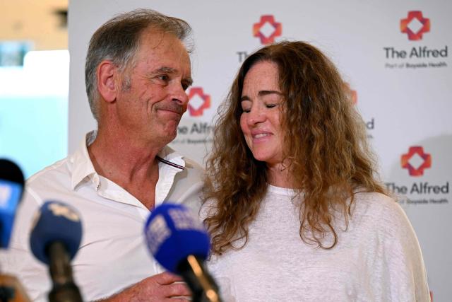 Phil Haines (L), husband of Australian politician Helen Haines, who lost both legs in an attack, and his cousin Jules Muir (R) take part in a media update on Helen Haines' condition at the Alfred Hospital in Melbourne on October 21, 2026. Australian lawmaker Helen Haines has had both legs removed, her husband told journalists on October 21, after what police called a "targeted" attack. (Photo by William WEST / AFP)