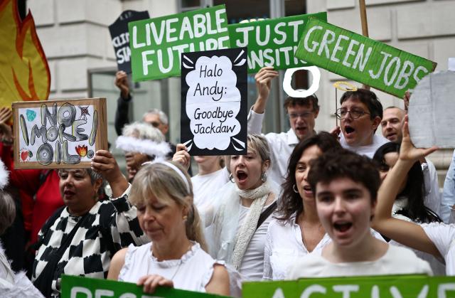 (FILES) Protesters hold up placards outside the Department of Energy in central London on October 6, 2026, demonstrating against the proposed development of the Rosebank and Jackdaw oil fields in the North Sea, north-west of Scotland. Britain's government announced on October 21, 2026 it had approved plans to begin drilling in a controversial gas field in the North Sea, ending months of speculation about the future of the divisive project. (Photo by Henry NICHOLLS / AFP)