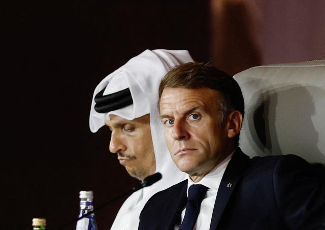 France's President Emmanuel Macron looks on as he sits next to Qatar's Prime Minister Sheikh Mohammed bin Abdulrahman al-Thani during the 9th Annual One Planet Sovereign Wealth Funds (OPSWF) Summit at the Rosewood Hotel in Lusail on October 21, 2026. The French president is undertaking a tour of key energy suppliers in the Gulf in an effort to secure oil and diesel and bring down prices in France. (Photo by Benoit Tessier / POOL / AFP)
