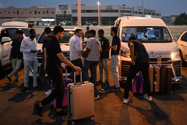 Travellers prepare to depart by road for Saudi Arabia in minibuses from Doha on October 21, 2026. Saudi Arabia has this month come under sustained attack from the Iran-backed Houthis, including a strike on Riyadh's international airport that was the kingdom's deadliest in years, as the war with the group escalates. (Photo by Mahmud HAMS / AFP)