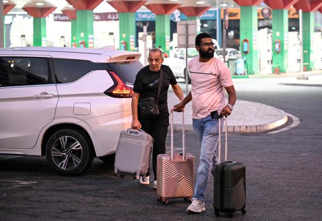 Travellers prepare to depart by road for Saudi Arabia in minibuses from Doha on October 21, 2026. Saudi Arabia has this month come under sustained attack from the Iran-backed Houthis, including a strike on Riyadh's international airport that was the kingdom's deadliest in years, as the war with the group escalates. (Photo by Mahmud HAMS / AFP)