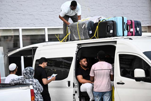 Travellers prepare to depart by road for Saudi Arabia in a minibus from Doha on October 21, 2026. Saudi Arabia has this month come under sustained attack from the Iran-backed Houthis, including a strike on Riyadh's international airport that was the kingdom's deadliest in years, as the war with the group escalates. (Photo by Mahmud HAMS / AFP)