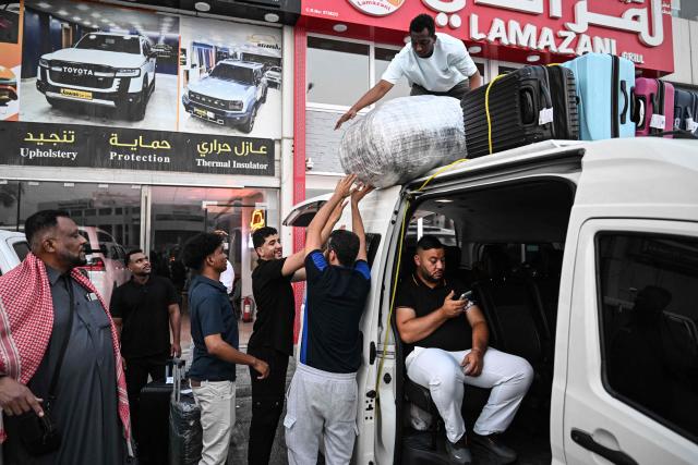 Travellers prepare to depart by road for Saudi Arabia in a minibus from Doha on October 21, 2026. Saudi Arabia has this month come under sustained attack from the Iran-backed Houthis, including a strike on Riyadh's international airport that was the kingdom's deadliest in years, as the war with the group escalates. (Photo by Mahmud HAMS / AFP)