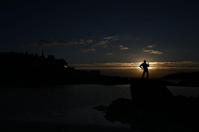 A boy plays on the rocks of the Sillon beach of Saint-Malo at sunset, western France on October 20, 2026. (Photo by Martin BUREAU / AFP)