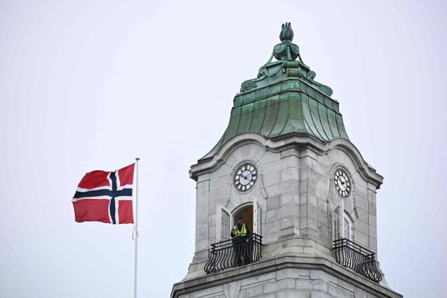 A policeman watches out from a tower close to Norway's parliament and the national flag in Oslo, Norway, where Ukraine's President is expected attend a parliament session on October 21, 2026, one day after a meeting in the Norwegian capital on the situation in Ukraine. Ukrainian President Volodymyr Zelensky arrived in Oslo on October 20, 2026 for talks with top US envoys. (Photo by Jonathan Nackstrand / AFP)