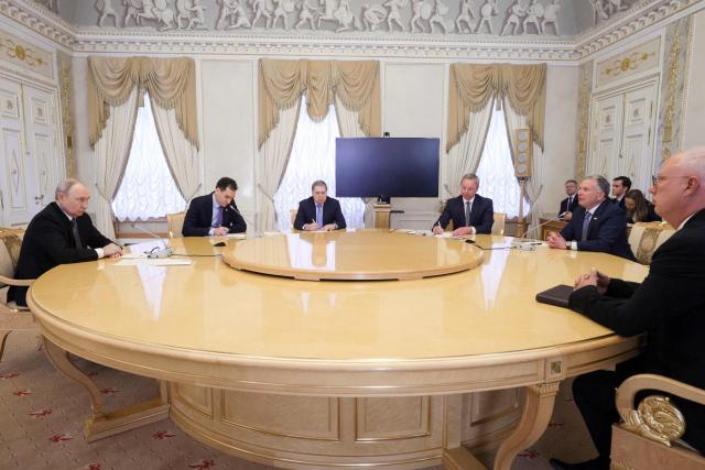 In this pool photograph distributed by the Russian state agency Sputnik, Russia's President Vladimir Putin (L), Kremlin foreign policy aide Yuri Ushakov (3rd L) and Russia's presidential envoy Kirill Dmitriev (R) attend a meeting with US special envoy Steve Witkoff (2nd R) in Saint Petersburg on October 21, 2026. (Photo by Gavriil GRIGOROV / POOL / AFP) / Editor's note: This image is distributed by the Russian state owned agency Sputnik