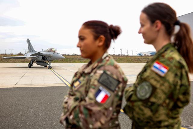 Military personnel from the Croatian Air Force and the French Air and Space Force stand in front of Croatian and French Rafale fighter aircraft during joint training at Zagreb Air Base in Pleso, near Zagreb on October 21, 2026. The training is part of FRA-ACE 26 (French Agile Combat Employment), marking the first deployment to Croatia of Rafale aircraft from France's 5th Fighter Wing and focusing on rapid deployment and operations with a reduced logistical footprint. Croatian Rafale pilots and aircraft technicians from the 91st Wing are also training alongside their French counterparts, exchanging operational and technical experience. (Photo by Goran Stanzl / AFP)