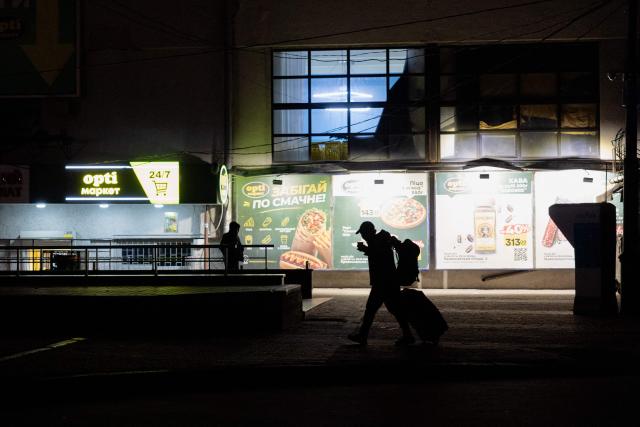A resident walks near the train station in Kharkiv on October 20, 2026, amid the Russian invasion of Ukraine. (Photo by Tetiana DZHAFAROVA / AFP)