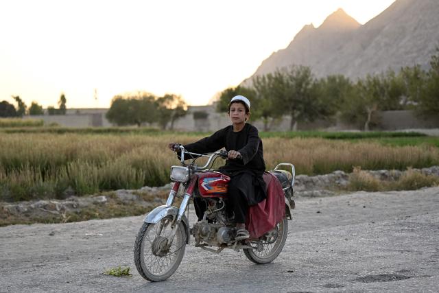 An Afghan youth rides a motorbike along a street at Spin Ziarat village in the Dand district of Afghanistan's Kandahar province on October 21, 2026. (Photo by Sanaullah SEIAM / AFP)