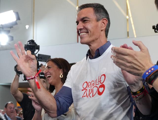 Spanish Prime Minister Pedro Sanchez smiles as he wears a T-shirt reading "Lefty pride" during a pre-campaign rally of the Spanish Socialist Party (PSOE) for the upcoming November 29 general election, in Burgos on October 21, 2026. (Photo by Cesar MANSO / AFP)