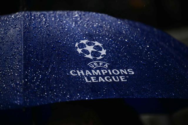 This photograph shows a logo of UEFA Champions League on an umbrella during a heavy rain prior to the UEFA Champions League, league phase matchday 3, football match between Como 1907 and Manchester United at the Stadio Giuseppe Sinigaglia in Como, northen Italy on October 21, 2026. (Photo by Marco BERTORELLO / AFP)