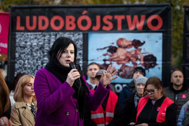 Pro-life activist Kaja Godek speaks at a rally and rosary prayer organised by conservative groups opposed to loosening abortion laws in Poland, in front of the Polish Parliament in central Warsaw, as the banner in the background reads “Genocide”, on October 21, 2026. Poland's parliament voted on Tuesday to liberalise abortion laws in the traditionally Catholic country, which has some of the EU's most restrictive rules on ending pregnancies. (Photo by Wojtek RADWANSKI / AFP)