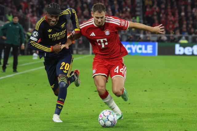 Arsenal's English midfielder #20 Noni Madueke (L) and Bayern Munich's Croatian defender #44 Josip Stanisic vie for the ball during the UEFA Champions League football match between FC Bayern Munich and Arsenal FC in Munich, southern Germany on October 21, 2026. (Photo by Karl-Josef HILDENBRAND / AFP)
