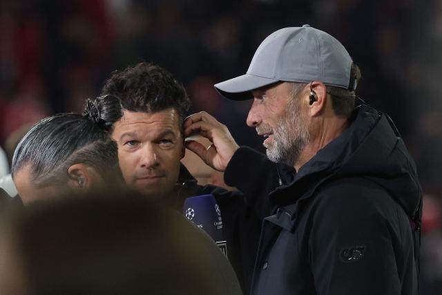 Germany's head coach Juergen Klopp (R) gives a TV interview next to former German football player Michael Ballack (C) at half-time during the UEFA Champions League football match between FC Bayern Munich and Arsenal FC in Munich, southern Germany on October 21, 2026. (Photo by Karl-Josef HILDENBRAND / AFP)
