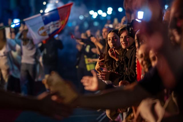 Students wave a giant Serbian flag as they are greeted by residents upon their arrival in central Belgrade on October 21, 2026, after walking for several days to attend the student movement's final major rally, due to be held in the capital the following day, ahead of Serbia's October 25 snap elections. The student-led movement emerged from nationwide protests following the November 2024 collapse of a railway station canopy in Novi Sad that killed 16 people, with demands expanding to include early elections in May 2025. The student movement formally entered the electoral race in September, challenging the Serbian Progressive Party (SNS). (Photo by Andrej ISAKOVIC / AFP)
