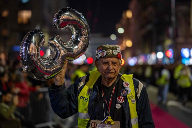 An older citizen waits for students to arrive in central Belgrade on October 21, 2026, after walking for several days to attend the student movement's final major rally, due to be held in the capital the following day, ahead of Serbia's October 25 snap elections. The student-led movement emerged from nationwide protests following the November 2024 collapse of a railway station canopy in Novi Sad that killed 16 people, with demands expanding to include early elections in May 2025. The student movement formally entered the electoral race in September, challenging the Serbian Progressive Party (SNS). (Photo by Andrej ISAKOVIC / AFP)