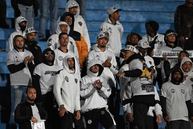 Fans of Atletico Mineiro cheer for their team during the Copa Sudamericana semifinal second leg football match between Uruguay's Montevideo City Torque and Brazil's Atletico Mineiro at the Centenario stadium in Montevideo on October 21, 2026. (Photo by Eitan ABRAMOVICH / AFP)