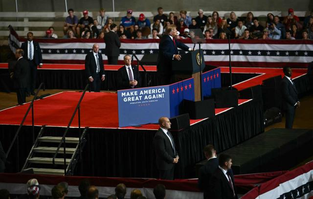 Members of the secret service stand around US President Donald Trump as he speaks during a campaign rally at T. Ed Garrison Arena in Pendleton, South Carolina on October 21, 2026. (Photo by Kent NISHIMURA / AFP)