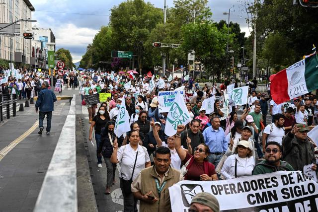 Health workers from the Mexican Social Security Institute (IMSS) shout slogans during a protest march demanding better wages and medications for patients at various hospitals in Mexico City on October 21, 2026. (Photo by Yuri CORTEZ / AFP)