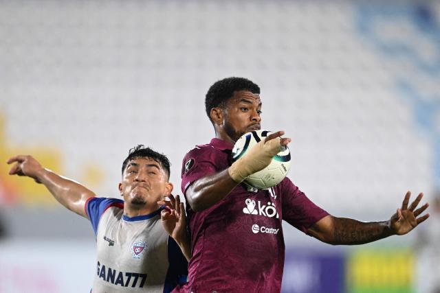Firpo's defender #06 Eduardo Vigil and Saprissa's Panamanian forward #07 Newton Williams fight for the ball during the first-leg play-in football match of the 2026 Concacaf Central American Cup between El Salvador's Club Deportivo Luis Angel Firpo and Costa Rica's Deportivo Saprissa at the Jorge "El Magico" Gonzalez Stadium in San Salvador on October 21, 2026. (Photo by MARVIN RECINOS / AFP)