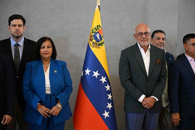 Opposition delegation head Dinorah Figuera (2nd L) and Venezuelan National Assembly President Jorge Rodriguez (2nd R), accompanied by members of their respective delegations, deliver a joint statement following the signing of an agreement at the closing of the third round of political dialogue talks at the Melia Hotel in Caracas on October 21, 2026. Venezuela's interim government and the opposition on Wednesday reaffirmed their commitment to holding presidential elections in the country under Washington-backed talks, the opposition said after a third round of negotiations. (Photo by Federico PARRA / AFP)