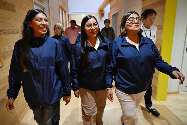 (From L-R) Wendy Sangama, Ketsi Yahuarcani and Belen mayor Lina Arista Lopez, guests from Peru's Belen district, visit a primary school in Nanmoku village, Japan's Gunma prefecture on September 26, 2026. In a misty mountain village in Japan, residents recently welcomed unlikely guests from a Peruvian district along the Amazon River, seeing a chance to revive an ageing community facing extinction. Nanmoku village officials hope a sister-city agreement, which promotes cultural and people-to-people ties, will ultimately attract young people from Belen to live in Nanmoku, although how they might obtain residency remains unclear. (Photo by Rie KIKUCHI / AFP) / To go with AFP story Japan-Peru-social-population-demographics, FOCUS by Natsuko Fukue and Junior Raborg