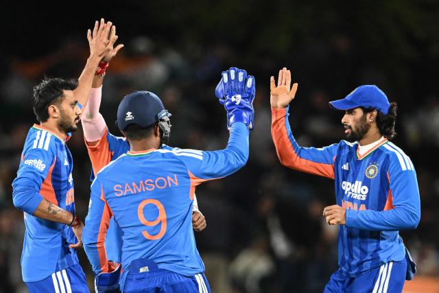 India's Axar Patel (L) and his teammates celebrate the dismissal of New Zealand's Finn Allen during the first Twenty20 international cricket match between New Zealand and India at Hagley Oval in Christchurch, on October 22, 2026. (Photo by Sanka VIDANAGAMA / AFP)