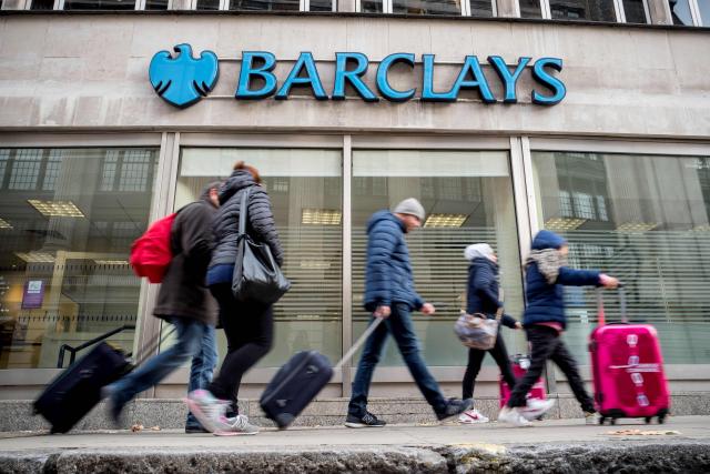 (FILES) Pedestrians walk past a branch of Barclays bank in central London on October 22, 2017. British bank Barclays on October 22, 2026 announced plans to cut around 5,000 jobs, or roughly five percent of its global workforce, as it leans on artificial intelligence to become more efficient. (Photo by Tolga Akmen / AFP)
