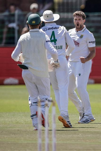 South Africa's Wiaan Mulder (R) celebrates after dismissing Australia's Travis Head on day five of the second Test match between South Africa and Australia at St Georges Park in Gqeberha on October 22, 2026. Australia were made to follow on after being dismissed for just 99 in reply to South Africa's first innings total of 425 for nine declared, a deficit of 326 runs, on day four at Gqeberha. (Photo by Marco Longari / AFP) / ALTERNATE CROP