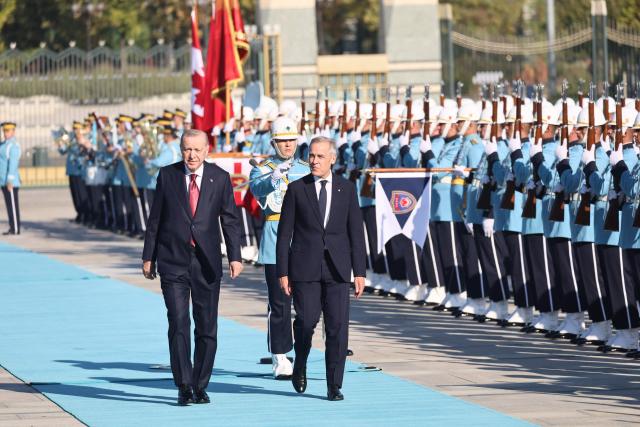 Turkish President Recep Tayyip Erdogan (L) welcomes Canadian Prime Minister Mark Carney (R) during an official ceremony at the Presidential Complex during his official visit to Turkey, in Ankara on October 22, 2026. (Photo by Adem ALTAN / AFP)