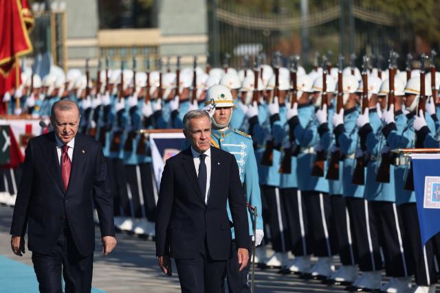 Turkish President Recep Tayyip Erdogan (L) welcomes Canadian Prime Minister Mark Carney (R) during an official ceremony at the Presidential Complex during his official visit to Turkey, in Ankara on October 22, 2026. (Photo by Adem ALTAN / AFP)