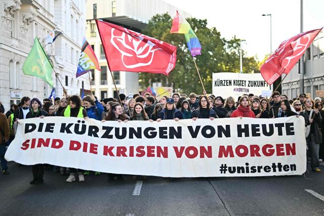 Protesters hold a banner reading "Today's cuts are tomorrow's crises" during a demonstration against university budget cuts outside the Technical University in Vienna, Austria, on October 22, 2026. (Photo by Joe Klamar / AFP)