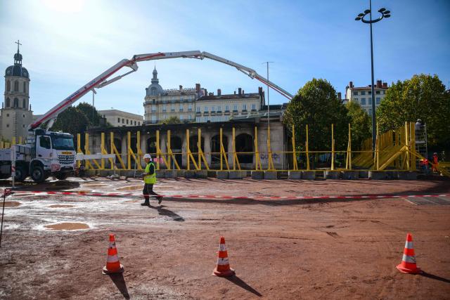 Workers secure the perimeter in Lyon, central-eastern France, on October 22, 2026, ahead of the start of repair work on the tourist information centre on Place Bellecour, which had been set alight by protesters on October 17. (Photo by OLIVIER CHASSIGNOLE / AFP)