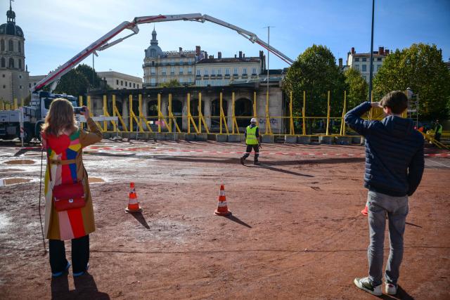 Workers secure the perimeter in Lyon, central-eastern France, on October 22, 2026, ahead of the start of repair work on the tourist information centre on Place Bellecour, which had been set alight by protesters on October 17. (Photo by OLIVIER CHASSIGNOLE / AFP)