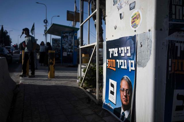 Israeli settlers wait next to a security post adorned with electoral posters in Gush Etzion, in the Israeli-occupied West Bank, on October 22, 2026, ahead of Israel's legislative election. Israel heads to the polls on October 27 in its first election since the October 7, 2023 Hamas-led attack, in what is seen as a referendum on the prime minister. (Photo by Jewel SAMAD / AFP)