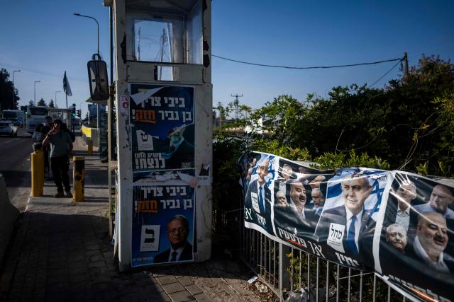 Israeli settlers wait next to a security post adorned with electoral posters in Gush Etzion, in the Israeli-occupied West Bank, on October 22, 2026, ahead of Israel's legislative election. Israel heads to the polls on October 27 in its first election since the October 7, 2023 Hamas-led attack, in what is seen as a referendum on the prime minister. (Photo by Jewel SAMAD / AFP)