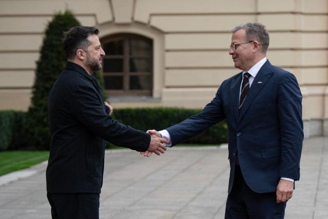 President of Ukraine Volodymyr Zelensky (L) welcomes Prime Minister of Finland Petteri Orpo during their meeting in Kyiv on October 22, 2026, amid the Russian invasion of Ukraine. (Photo by Genya SAVILOV / AFP)