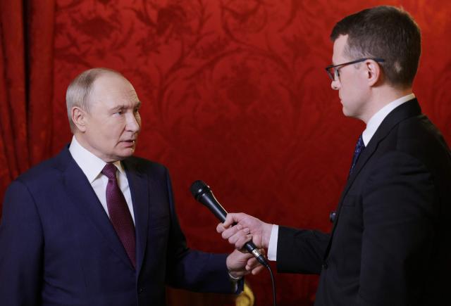 In this pool photograph distributed by the Russian state agency Sputnik, Russia's President Vladimir Putin answers a question of Russian journalist Pavel Zarubin after giving a speech during a festive gathering marking the 150th anniversary of the Russian Union of Theatre Workers at the Bolshoi Theatre in Moscow on October 22, 2026. (Photo by Gavriil Grigorov / POOL / AFP)