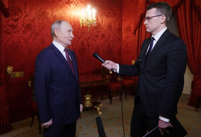 In this pool photograph distributed by the Russian state agency Sputnik, Russia's President Vladimir Putin answers a question of Russian journalist Pavel Zarubin after giving a speech during a festive gathering marking the 150th anniversary of the Russian Union of Theatre Workers at the Bolshoi Theatre in Moscow on October 22, 2026. (Photo by Gavriil Grigorov / POOL / AFP)