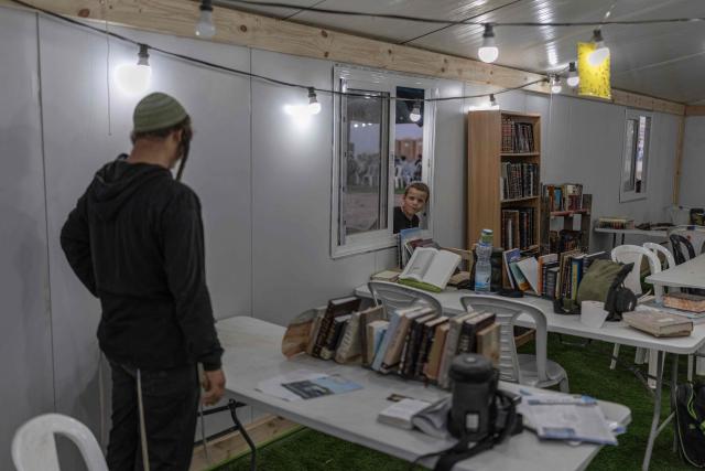 Israeli right-wing members of the Nachala settler organisation are seen at a makeshift synagogue at a newly built camp site at a field near the Israeli Kibbutz of Nahal Oz in southern Israel, by the Israel-Gaza border on October 22, 2026. (Photo by Ilia YEFIMOVICH / AFP)
