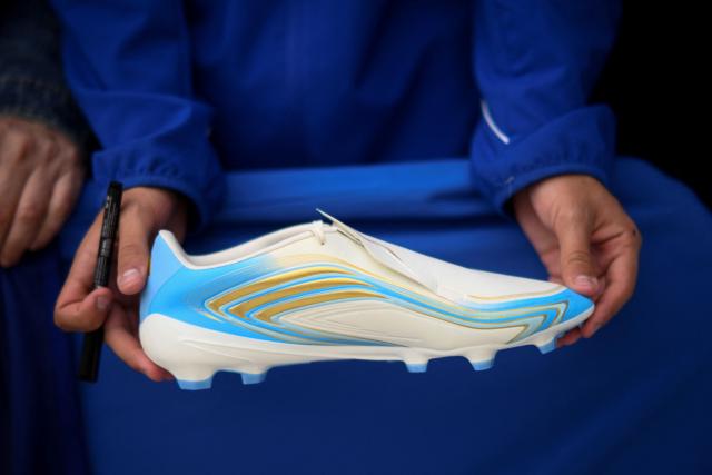 A fan holds a sport shoe while waiting for autographs of Lionel Messi prior an event with the Argentinian football legend at the sport hall in Oviedo on October 22, 2026. Lionel Messi will receive the 2026 Princess of Asturias Awards for Sport on October 23, 2026. (Photo by MIGUEL RIOPA / AFP)